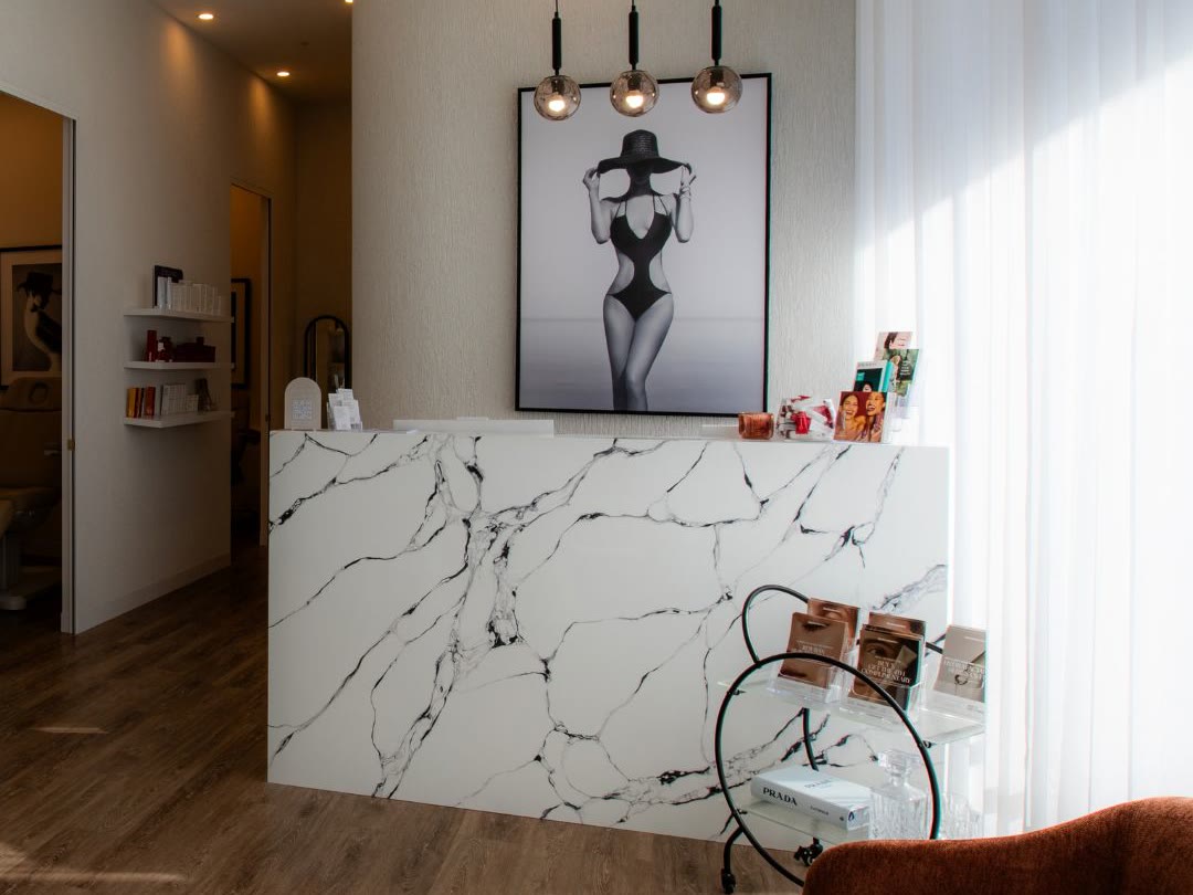 MedAesthetics clinic reception with a marble desk and brand artwork
