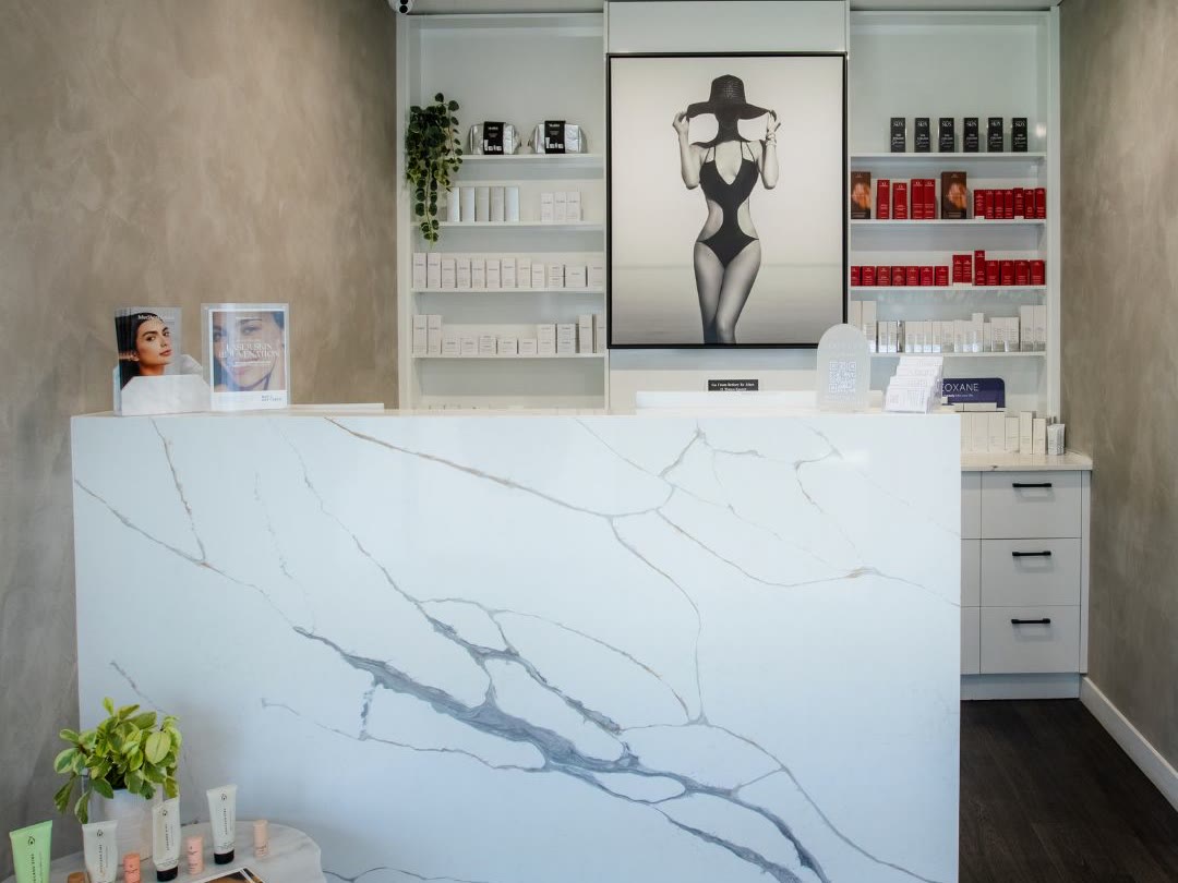 MedAesthetics clinic reception with marble desk and product shelves